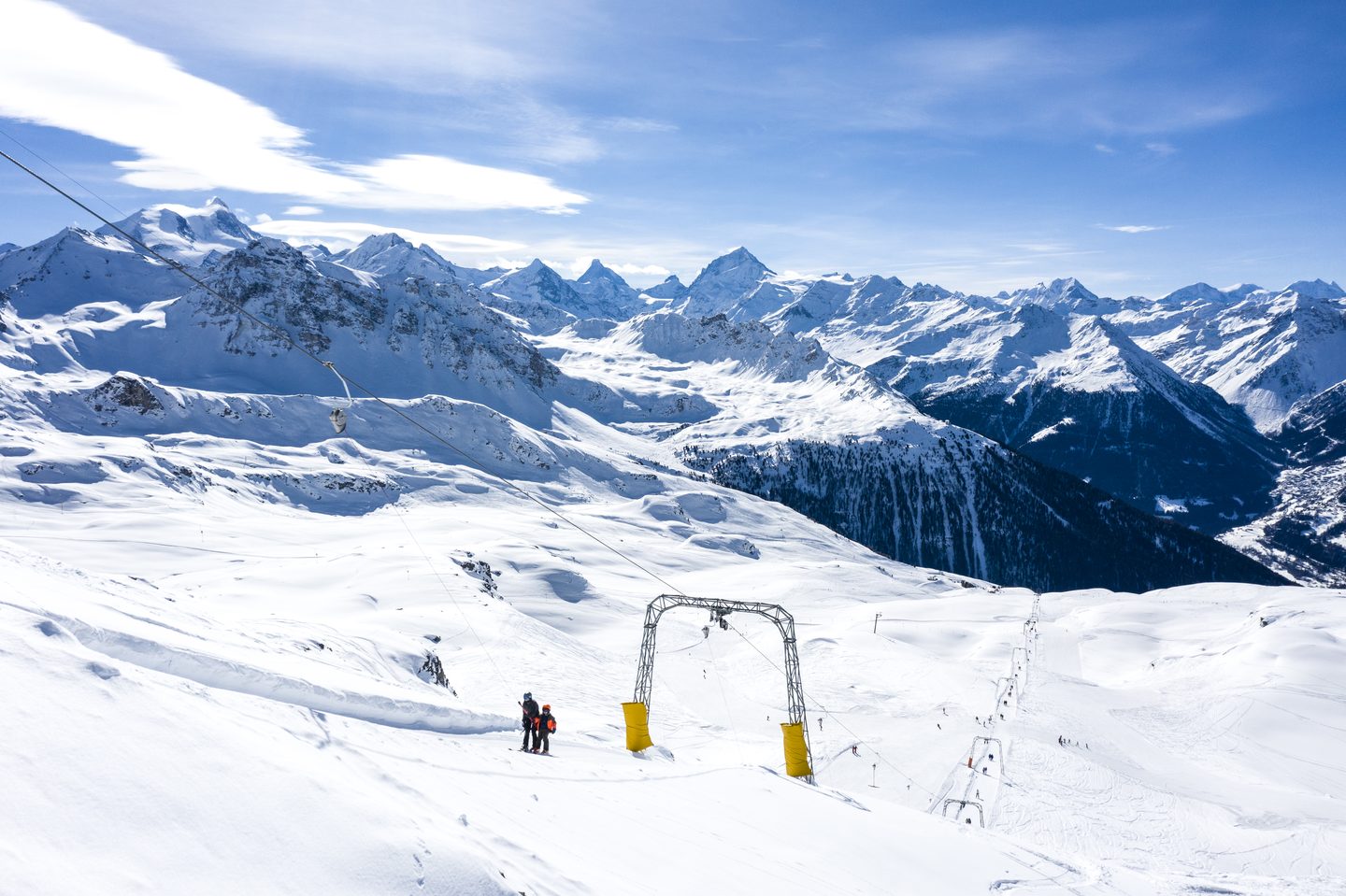 Un téléski du domaine d’altitude et, à l’horizon, les sommets des Alpes valaisannes